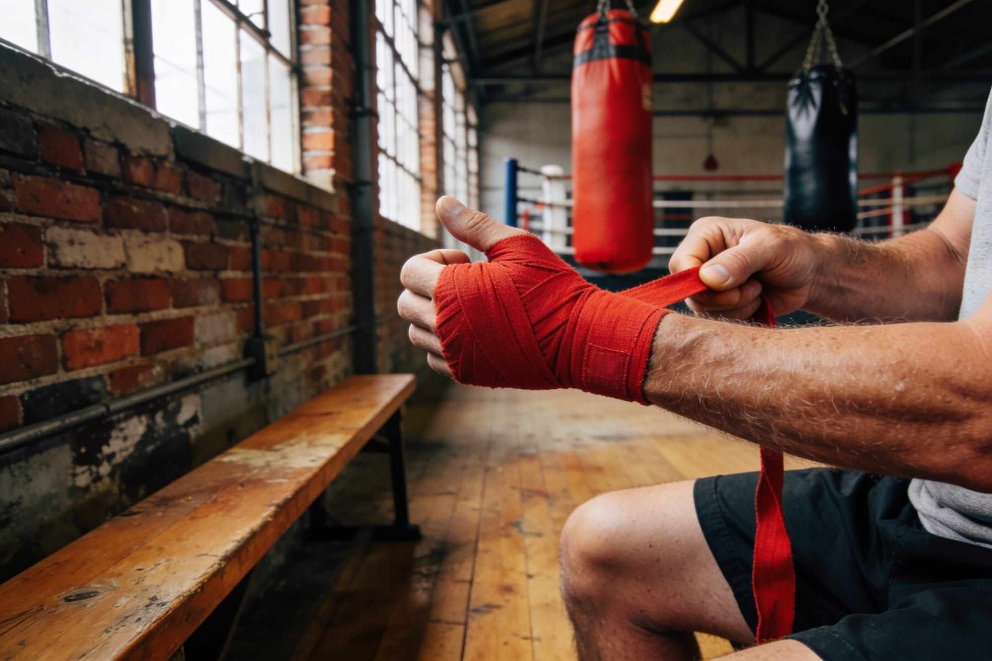 Close-up of hands being wrapped in red hand wraps