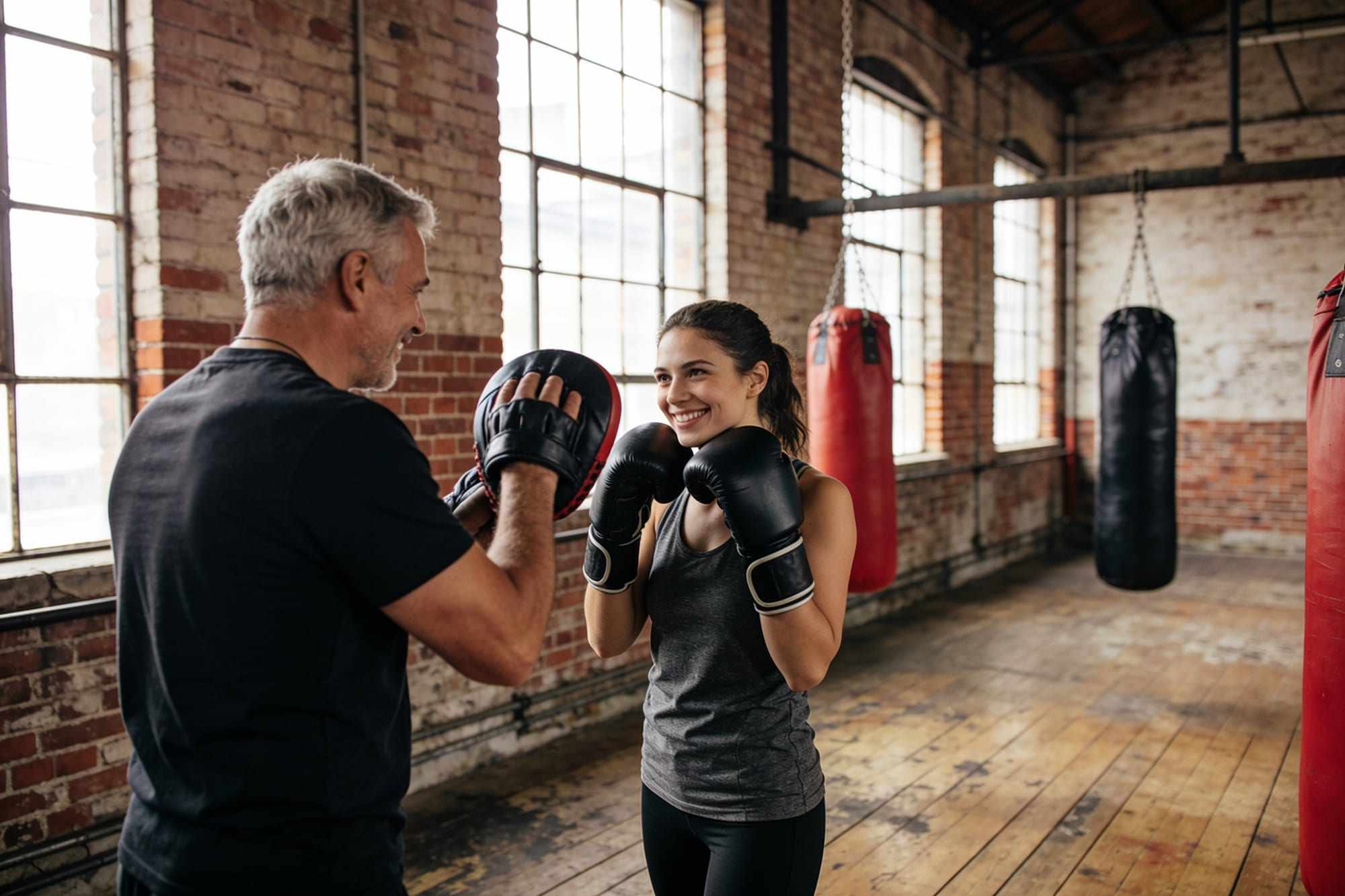 A coach showing a beginner how to hold her guard